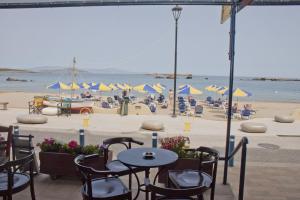 a beach area with chairs, tables and umbrellas at Danaos Hotel in Chania