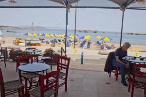 a woman sitting at a table under an umbrella at Danaos Hotel in Chania