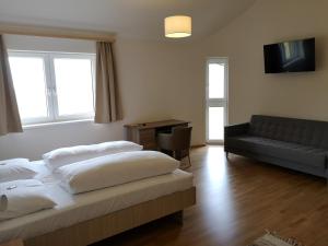 ein Hotelzimmer mit 2 Betten und einem Sofa in der Unterkunft Hotel Restaurant Winterbach in Sankt Anton an der Jessnitz
