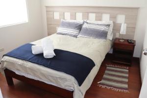 een slaapkamer met een groot bed met blauwe en witte kussens bij Cayma Apart's II in Arequipa