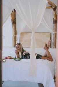 een vrouw die op een bed ligt en eten eet bij Hotel Okaan in Chichén-Itzá