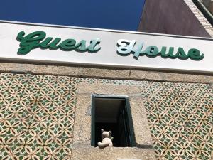 a teddy bear sitting in a window of a building at Casa da Avó Lurdes in Póvoa de Varzim