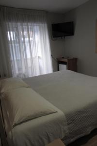 - une chambre avec un lit blanc et une fenêtre dans l'établissement Salku Serviced Rooms, à Tirana