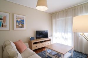 a living room with a couch and a tv and a table at APA 12 in Espinho