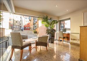 a room with a table and chairs and a large window at Holyrood Aparthotel in Edinburgh