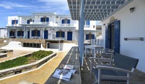 a balcony with chairs and a view of a building at Nostos Beachfront Apartments & Studios in Agios Ioannis