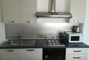 a kitchen with a sink and a microwave at B&B Stadio Apartment in Pordenone