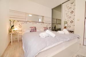 a bedroom with a large white bed with towels on it at Apartments Basioli in Zadar +30 photos