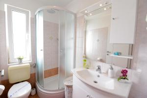 a bathroom with a sink and a toilet and a mirror at Apartments Basioli in Zadar