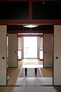 um quarto com portas e uma mesa no meio em ゲストハウス たまのや em Hyuga
