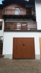 a large wooden door on a building with a balcony at il Nido in Tonadico