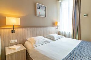 a bedroom with a bed and a lamp and a window at Antinéa in Saint Malo