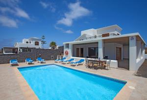 a villa with a swimming pool in front of a house at Villa Hortensia in Playa Blanca