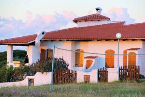 une maison avec une clôture devant elle dans l'établissement Sa Fiorida case vacanze, à Valledoria