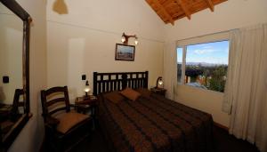 1 dormitorio con cama y ventana grande en Puente Austral en San Carlos de Bariloche