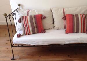 a couch with striped pillows on a wooden floor at Garros in Fronsac