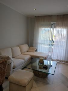 a living room with a white couch and a glass table at APARTAMENTO PUERTO BANUS/PLAYA in Marbella +30 photos