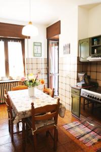 eine Küche mit einem Tisch mit Blumen darauf in der Unterkunft appartamento delle rose in Sesto Calende