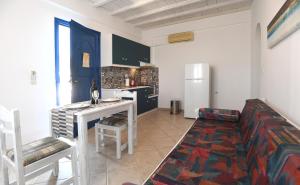a living room with a couch and a kitchen at Nostos Beachfront Apartments & Studios in Agios Ioannis