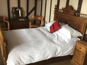 a large white bed with a red pillow on it at The Kilverts Inn in Hay-on-Wye
