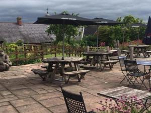 a group of tables and chairs with an umbrella at The Kilverts Inn in Hay-on-Wye