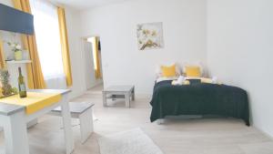 een witte slaapkamer met een bed en een tafel bij Niko Apartment Vienna in Wenen
