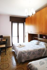 1 Schlafzimmer mit 2 Betten, einem Tisch und einem Schreibtisch in der Unterkunft appartamento delle rose in Sesto Calende