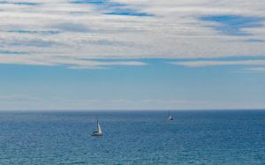 Tre barche a vela nell'oceano sotto un cielo nuvoloso di Vela d’Oro a Pietra Ligure