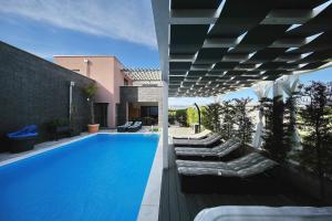 a swimming pool with chaise lounges next to a house at Villas A & N in Zaton