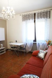 ein Wohnzimmer mit einem roten Sofa und einem Tisch in der Unterkunft appartamento delle rose in Sesto Calende