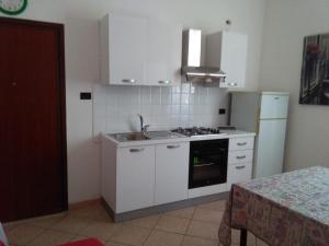 a kitchen with white cabinets and a stove top oven at casa vacanza Regina in Parma +3 photos