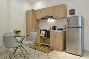 a kitchen with a refrigerator and a table and chairs at Alexis House Studio in Pylos