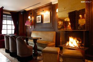 a living room with a fireplace and a table and chairs at Mimi's Hotel Soho in London