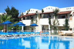 ein großer Pool mit blauen Sonnenschirmen und Stühlen in der Unterkunft Summer Garden Suites Beach Hotel in Bitez