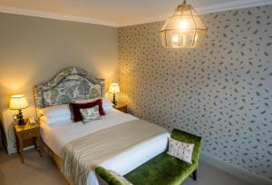 um quarto com uma cama e uma cadeira num quarto em The Maids Head Hotel em Norwich