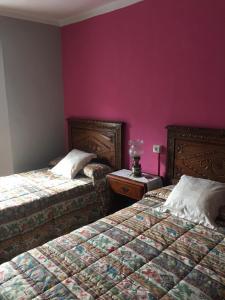 two beds in a room with purple walls at MRZ Rentals San Martín de Luiña in San Martín de Luiña