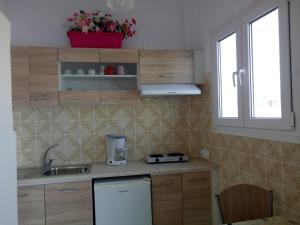 a kitchen with wooden cabinets and a sink and a window at Meletis Studios in Parikia