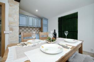 a dining room with a table with plates and wine glasses at Holiday Home Petar in Drage