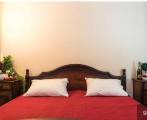 a bed with a red blanket and two white pillows at Apartment Blue in Sveti Stefan