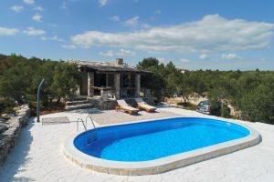 a pool in front of a house with a building at Holiday Home Petar in Drage
