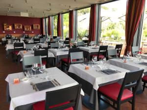 a dining room with white tables and red chairs at Hapimag Resort Tonda in Montaione