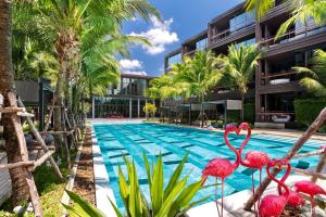 een zwembad met flamingo's voor een gebouw bij Lucky Holidays in Saturdays Residence in Rawai Beach