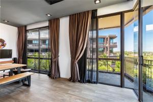 a living room with large windows and a wooden table at Lucky Holidays in Saturdays Residence in Rawai Beach