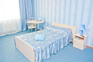 1 dormitorio con 1 cama y 1 mesa con silla en Grand City Hotel, en Chita