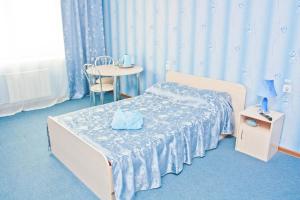 a bedroom with a bed and a table with a chair at Grand City Hotel in Chita