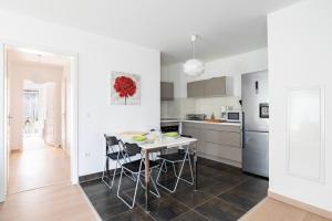 eine weiße Küche mit einem Tisch und Stühlen in der Unterkunft CityCosy Strasbourg - Neudorf Garden Bucarest in Straßburg + 24 Fotos