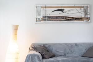 ein Wohnzimmer mit einem grauen Sofa und einem Spiegel in der Unterkunft CityCosy Strasbourg - Neudorf Garden Bucarest in Straßburg