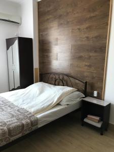 ein Schlafzimmer mit einem Bett und einer Holzwand in der Unterkunft Apartments on Panteleimonovskaya in Odessa