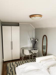 a bedroom with a bed and a table and a mirror at Seaview Luxury Apartment Grasholmen in Stavanger