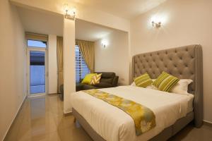 a bedroom with a large bed and a chair at Ahn-Yi Residence in Brinchang